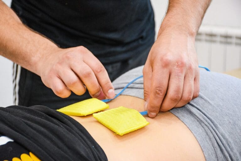 Close up of hands setting up electo muscle stimulators